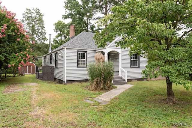 9349 Quinnford Blvd, Chesterfield, VA 23237 - view of front of property with a storage shed, a front lawn, a shingled roof, and a chimney