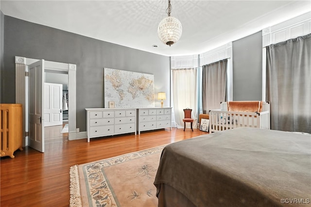 241 S Sycamore St, Petersburg, VA 23803 - bedroom featuring wood finished floors, radiator heating unit, and a chandelier