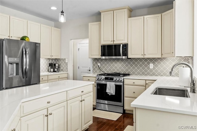 3057 Hunton Cottage Ln, Glen Allen, VA 23059 - kitchen featuring stainless steel appliances, cream cabinets, dark wood-style flooring, tasteful backsplash, and pendant lighting