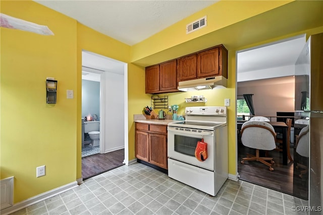 1593 Constitution Dr, Henrico, VA 23238 - kitchen with white electric stove, under cabinet range hood, freestanding refrigerator, and brown cabinetry