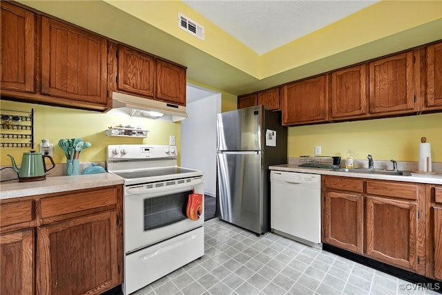 1593 Constitution Dr, Henrico, VA 23238 - kitchen with white appliances, under cabinet range hood, light countertops, and brown cabinetry
