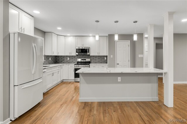 4712 Kyloe Ln, Moseley, VA 23120 - kitchen with stainless steel appliances, decorative backsplash, light stone countertops, white cabinets, and light wood-type flooring