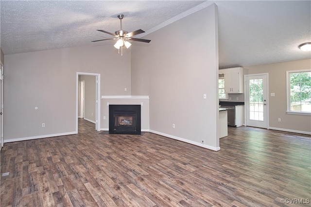 6434 Anderson Hwy, Powhatan, VA 23139 - unfurnished living room featuring a textured ceiling, vaulted ceiling, dark wood-type flooring, ceiling fan, and a fireplace with flush hearth