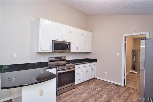 6434 Anderson Hwy, Powhatan, VA 23139 - kitchen with appliances with stainless steel finishes, dark countertops, white cabinets, a peninsula, and dark wood-style flooring