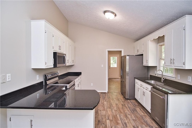 6434 Anderson Hwy, Powhatan, VA 23139 - kitchen featuring stainless steel appliances, vaulted ceiling, a textured ceiling, plenty of natural light, and white cabinets