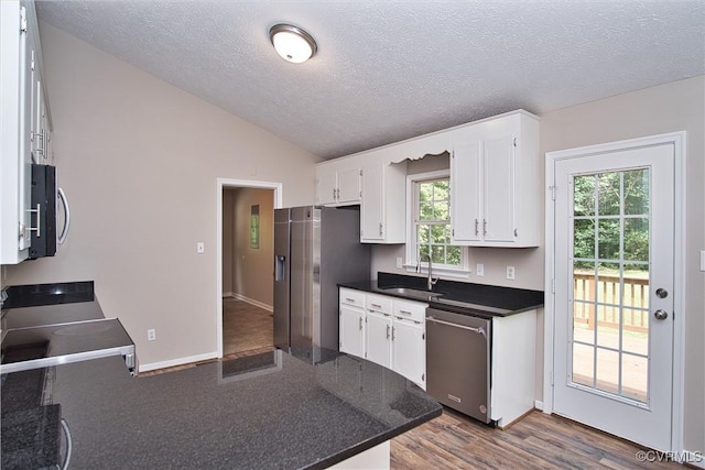 6434 Anderson Hwy, Powhatan, VA 23139 - kitchen featuring appliances with stainless steel finishes, dark countertops, white cabinets, a textured ceiling, and vaulted ceiling