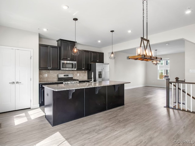 341 Crofton Village Ter Unit Kd, Chesterfield, VA 23114 - kitchen with appliances with stainless steel finishes, a large island with sink, light wood-type flooring, tasteful backsplash, and a breakfast bar area