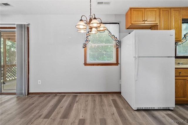 11900 James River Dr, North Prince George, VA 23860 - kitchen with freestanding refrigerator, a chandelier, light wood finished floors, and plenty of natural light