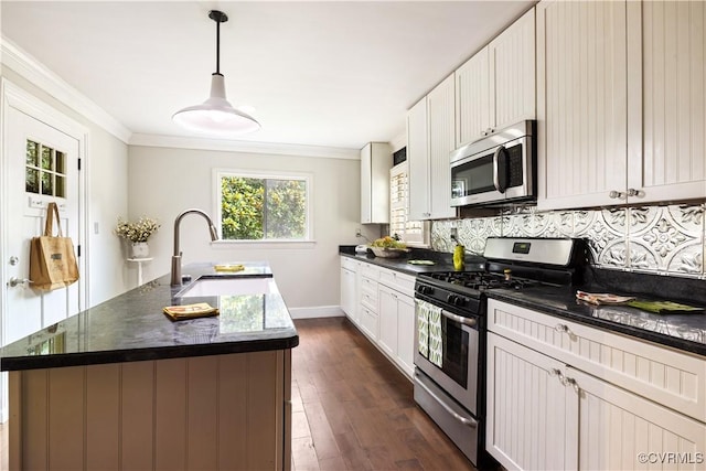 544 High St, Petersburg, VA 23803 - kitchen with appliances with stainless steel finishes, ornamental molding, decorative backsplash, an island with sink, and dark wood finished floors