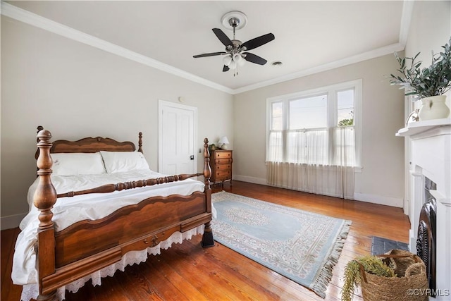 544 High St, Petersburg, VA 23803 - bedroom with wood finished floors, a fireplace with flush hearth, ornamental molding, ceiling fan, and estacked washer and dryer