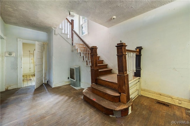 415 W 24th St, Richmond, VA 23225 - staircase with wood-type flooring, a textured ceiling, and heating unit