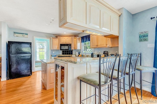 1382 Glebe Landing Rd, Center Cross, VA 22437 - kitchen featuring black appliances, light wood-style floors, light brown cabinetry, light stone countertops, and a peninsula