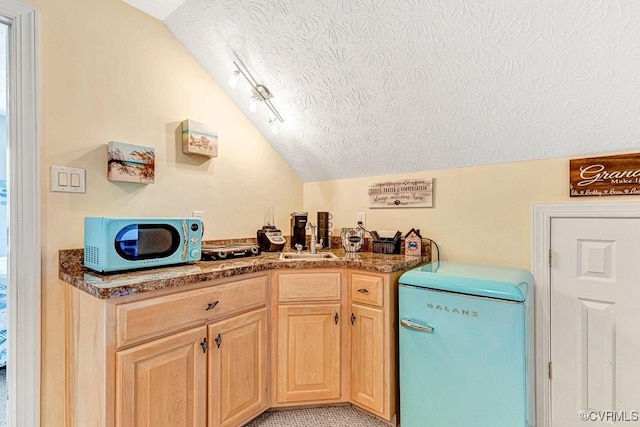 1382 Glebe Landing Rd, Center Cross, VA 22437 - kitchen featuring refrigerator, stainless steel microwave, lofted ceiling, a textured ceiling, and light brown cabinetry