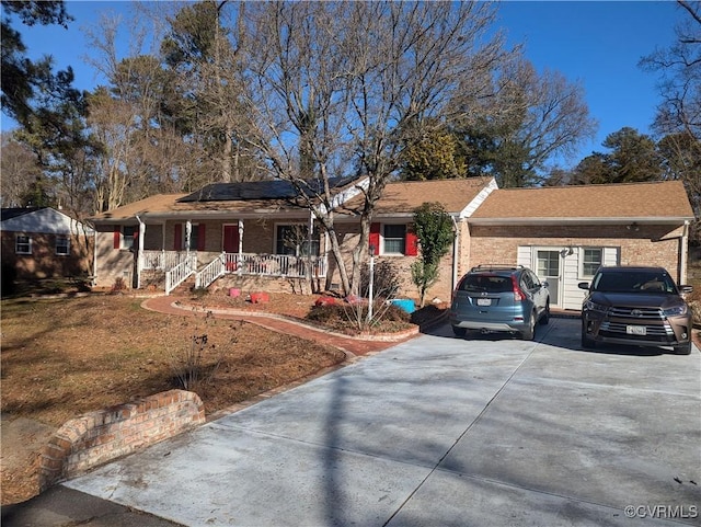 2021 Cedarhurst Dr, Richmond, VA 23225 - ranch-style house featuring a porch, brick siding, concrete driveway, and roof mounted solar panels