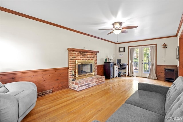 11906 Exbury Ter, Midlothian, VA 23114 - living area with wood finished floors, a ceiling fan, a brick fireplace, crown molding, and a wainscoted wall
