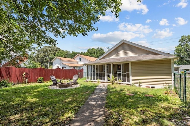 2210 W City Point Rd, Hopewell, VA 23860 - back of property featuring an outdoor fire pit, a sunroom, and a fenced backyard