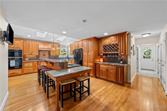 18030 W County Line Rd, Midlothian, VA 23112 - kitchen with black appliances, backsplash, a breakfast bar area, light wood-type flooring, and recessed lighting