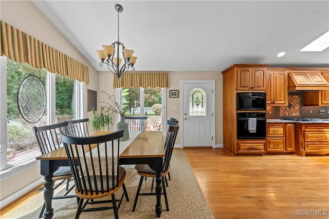 18030 W County Line Rd, Midlothian, VA 23112 - dining space featuring a chandelier, light wood-style flooring, a skylight, and lofted ceiling