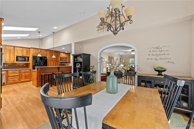 18030 W County Line Rd, Midlothian, VA 23112 - dining room with light wood-style flooring, a chandelier, lofted ceiling, arched walkways, and a skylight