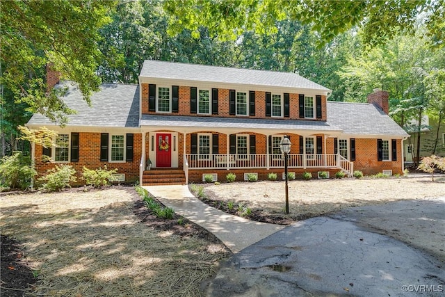 2613 Teaberry Dr, North Chesterfield, VA 23236 - colonial-style house featuring a chimney, covered porch, and brick siding