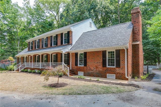 2613 Teaberry Dr, North Chesterfield, VA 23236 - colonial house with brick siding, a chimney, a shingled roof, covered porch, and view of scattered trees