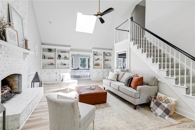 2613 Teaberry Dr, North Chesterfield, VA 23236 - living area featuring high vaulted ceiling, stairway, light wood-type flooring, a brick fireplace, and a skylight