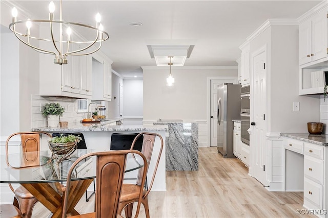 2613 Teaberry Dr, North Chesterfield, VA 23236 - kitchen with white cabinets, light wood-type flooring, a chandelier, crown molding, and a peninsula