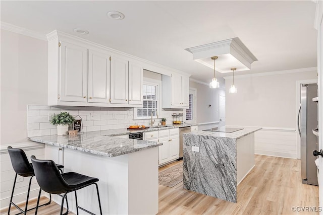 2613 Teaberry Dr, North Chesterfield, VA 23236 - kitchen featuring a peninsula, a kitchen island, white cabinetry, light wood-style flooring, and light stone counters