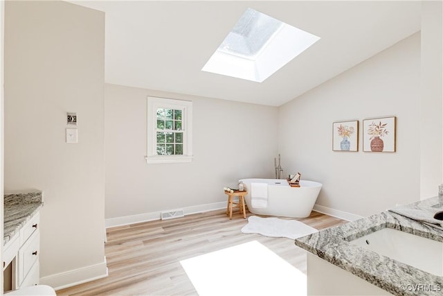2613 Teaberry Dr, North Chesterfield, VA 23236 - bathroom featuring vanity, a skylight, a freestanding bath, wood finished floors, and lofted ceiling