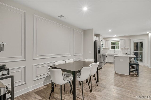 5845 Austin Woods Dr, North Chesterfield, VA 23234 - dining space featuring light wood-style flooring, recessed lighting, and a decorative wall
