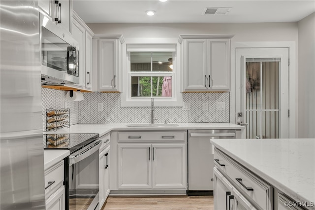 5845 Austin Woods Dr, North Chesterfield, VA 23234 - kitchen featuring stainless steel appliances, decorative backsplash, recessed lighting, light wood finished floors, and white cabinets