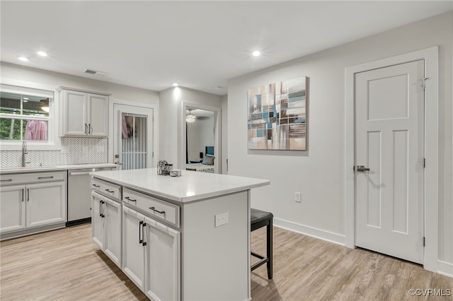 5845 Austin Woods Dr, North Chesterfield, VA 23234 - kitchen featuring dishwasher, a breakfast bar, light countertops, a center island, and light wood-style floors