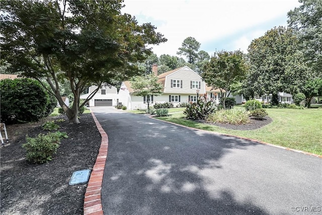 5618 Buxton Ct, Chester, VA 23831 - view of front of house with driveway, a front yard, a gambrel roof, a garage, and a chimney