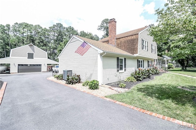 5618 Buxton Ct, Chester, VA 23831 - view of side of home with a detached garage, roof with shingles, a chimney, an outbuilding, and a lawn