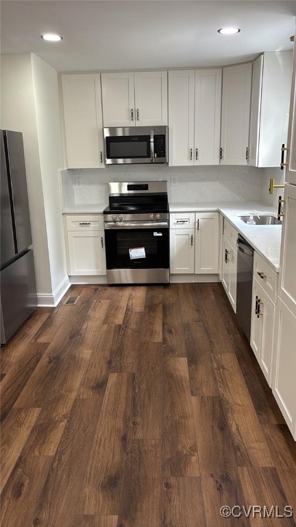 8057 Hermitage Rd, Henrico, VA 23228 - kitchen with appliances with stainless steel finishes, dark wood-style flooring, light countertops, white cabinetry, and recessed lighting