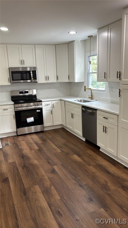 8057 Hermitage Rd, Henrico, VA 23228 - kitchen with appliances with stainless steel finishes, dark wood-style flooring, light countertops, and recessed lighting