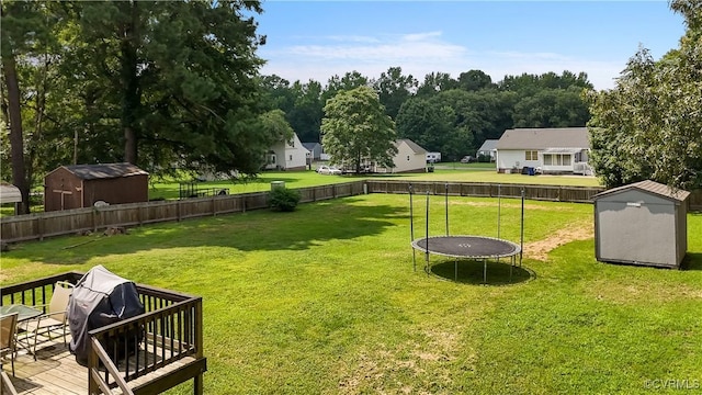 24716 Woodstream Ln, North Dinwiddie, VA 23803 - fenced backyard featuring a storage unit, a trampoline, and a wooden deck