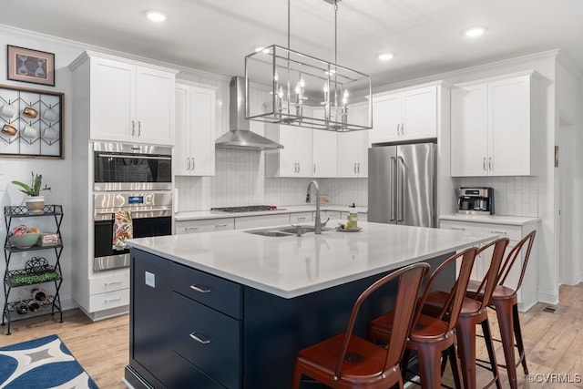 13518 Kelham Rd, Midlothian, VA 23113 - kitchen with appliances with stainless steel finishes, wall chimney exhaust hood, light countertops, white cabinets, and an island with sink