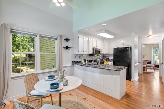 1424 Laurel Top Dr, Midlothian, VA 23114 - kitchen with freestanding refrigerator, a peninsula, white cabinets, stainless steel microwave, and light wood-style flooring