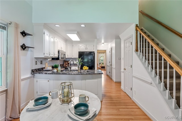 1424 Laurel Top Dr, Midlothian, VA 23114 - kitchen with freestanding refrigerator, a peninsula, white cabinets, stainless steel microwave, and light wood finished floors