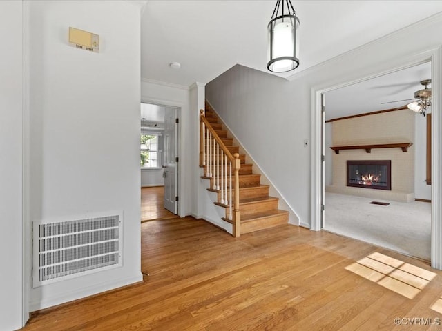 2340 Scarsborough Dr, North Chesterfield, VA 23235 - stairs featuring wood finished floors, a ceiling fan, crown molding, and a brick fireplace