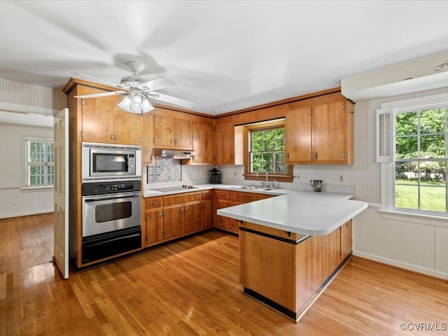 2340 Scarsborough Dr, North Chesterfield, VA 23235 - kitchen featuring stainless steel appliances, a peninsula, light countertops, light wood-type flooring, and under cabinet range hood