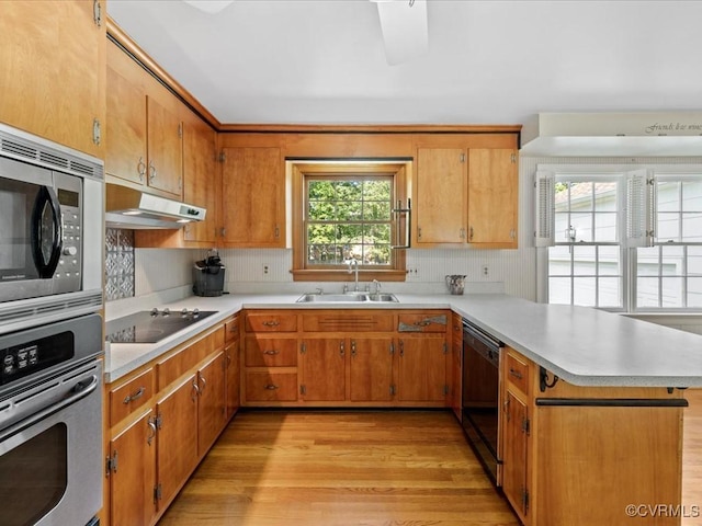 2340 Scarsborough Dr, North Chesterfield, VA 23235 - kitchen featuring black appliances, under cabinet range hood, light countertops, a peninsula, and light wood-style flooring