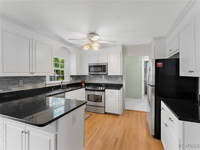 2730 Dalkeith Dr, Henrico, VA 23233 - kitchen with appliances with stainless steel finishes, white cabinetry, a peninsula, decorative backsplash, and crown molding