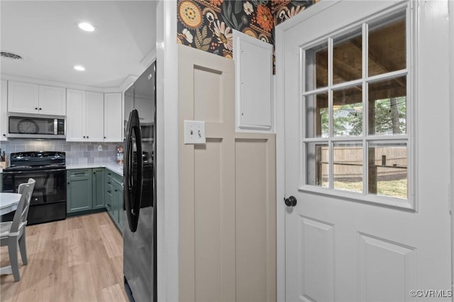 611 Queensway Rd, North Chesterfield, VA 23236 - kitchen featuring stainless steel microwave, black / electric stove, freestanding refrigerator, white cabinetry, and light wood finished floors