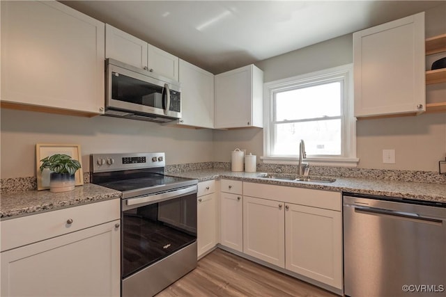 1117 Penobscot Rd, Henrico, VA 23227 - kitchen with stainless steel appliances, open shelves, light wood-type flooring, white cabinets, and light stone countertops