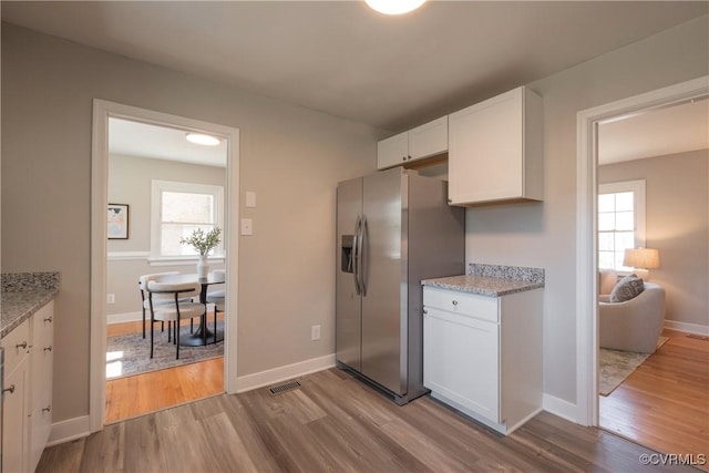 1117 Penobscot Rd, Henrico, VA 23227 - kitchen with stainless steel fridge with ice dispenser, white cabinets, light wood-style floors, and plenty of natural light
