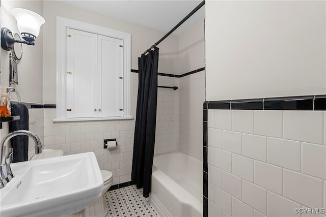 501 E Azalea Ave, Richmond, VA 23227 - bathroom featuring tile walls, shower / bath combo with shower curtain, and a wainscoted wall