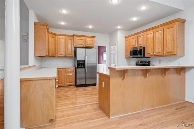 17220 Dawn Ct, Amelia Courthouse, VA 23002 - kitchen featuring stainless steel appliances, a peninsula, light wood-style flooring, a breakfast bar area, and recessed lighting