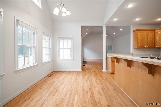 17220 Dawn Ct, Amelia Courthouse, VA 23002 - kitchen featuring ornate columns, a kitchen bar, vaulted ceiling, recessed lighting, and light countertops